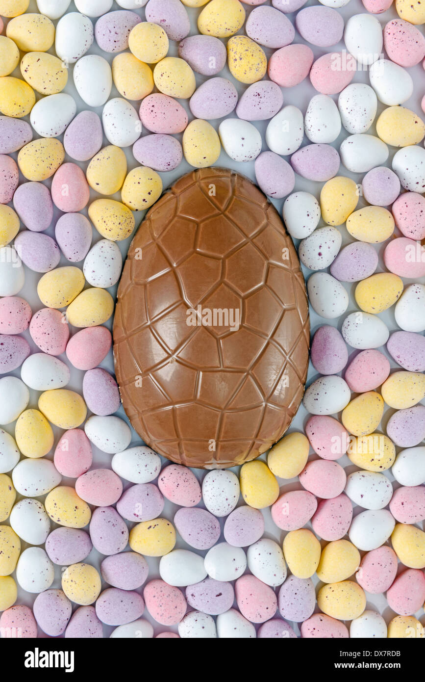 A chocolate Easter egg surrounded by candy covered mini eggs Stock Photo