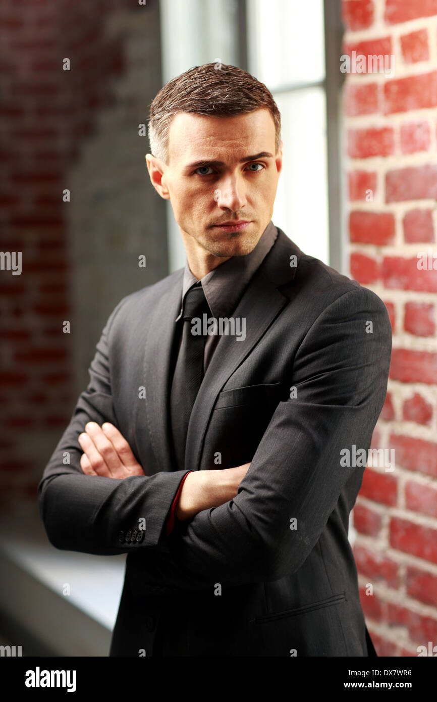 Confident businessman standing with arms folded Stock Photo