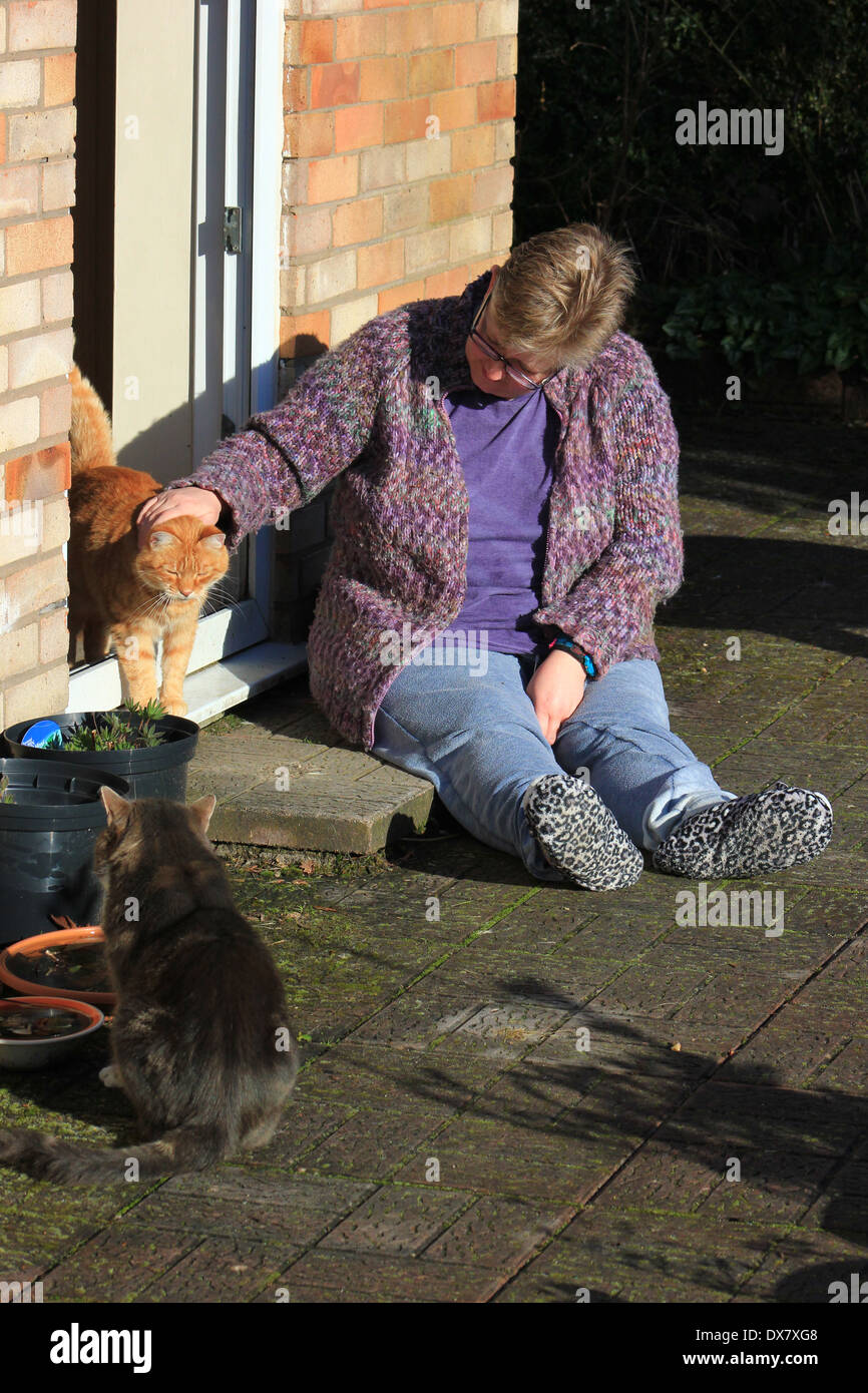 Woman with two cats on doorstep Stock Photo