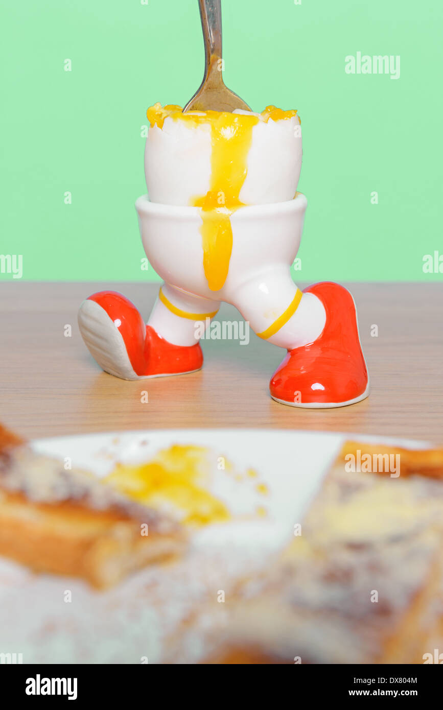 Boiled egg and toast breakfast with a spoon making the yolk run. Stock Photo
