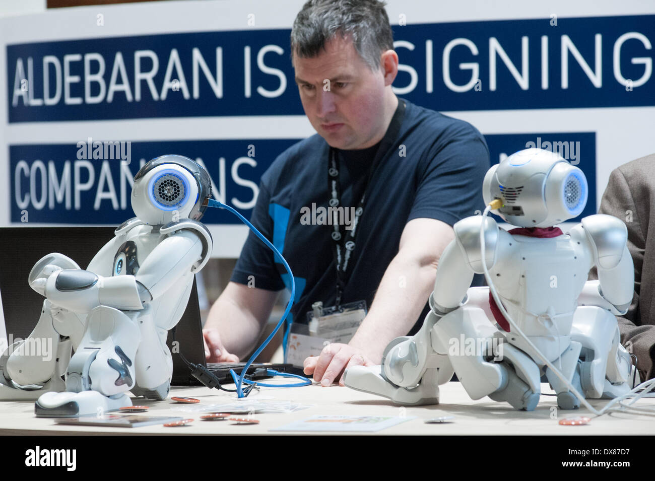 Lyon, France. 19th Mar, 2014. an Aldebaran engineer works with NAO Robots  at Innorobo 2014, the 4th international trade show on service robotics. Credit:  Piero Cruciatti/Alamy Live News Stock Photo