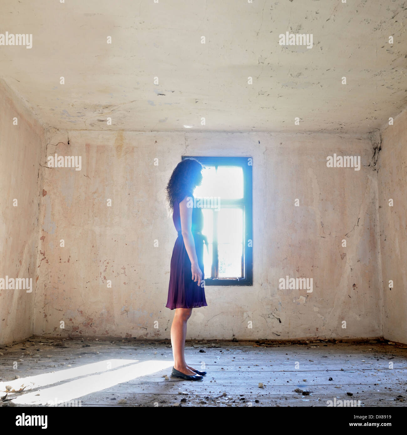 Woman standing by the window Stock Photo
