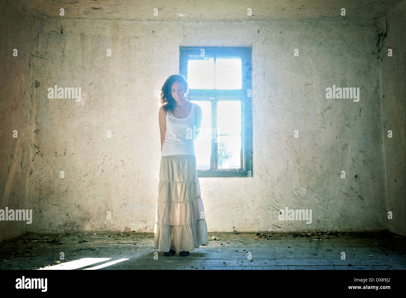 Woman standing by the window Stock Photo