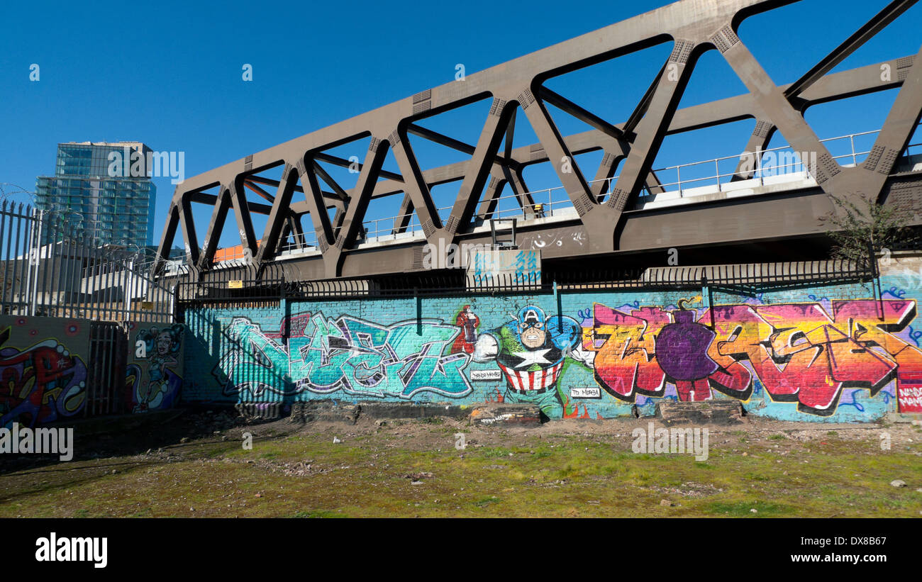 Graffiti adorns hoardings beneath the new East London Line extension overground railway bridge Shoreditch London UK KATHY DEWITT Stock Photo