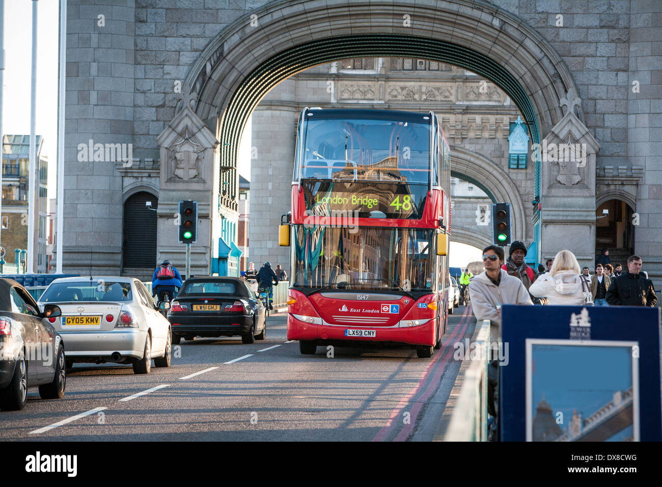 London red bus crossing Tower Bridge, on the River Thames, London UK Stock Photo