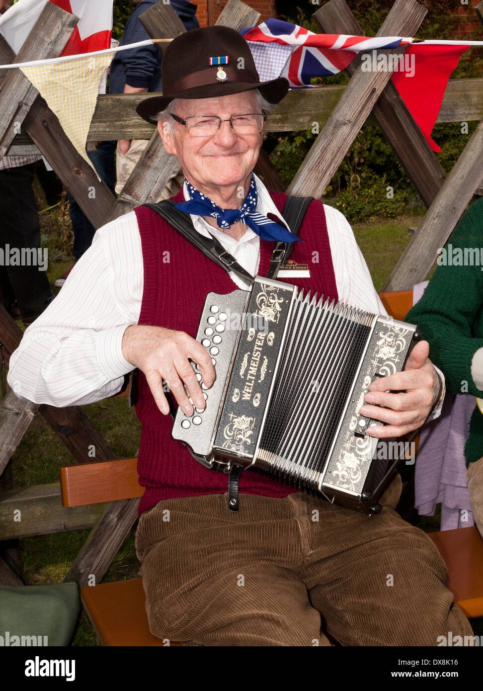 A mature man wearing 1940's clothing playing a piano accordion Stock Photo
