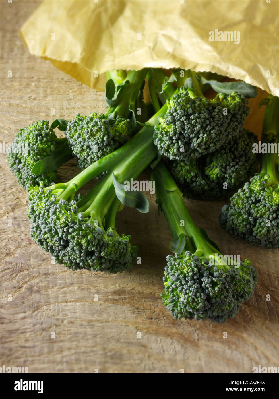 close up of Broccoli spilling out of a paper bag on a wooden background, top shot Stock Photo