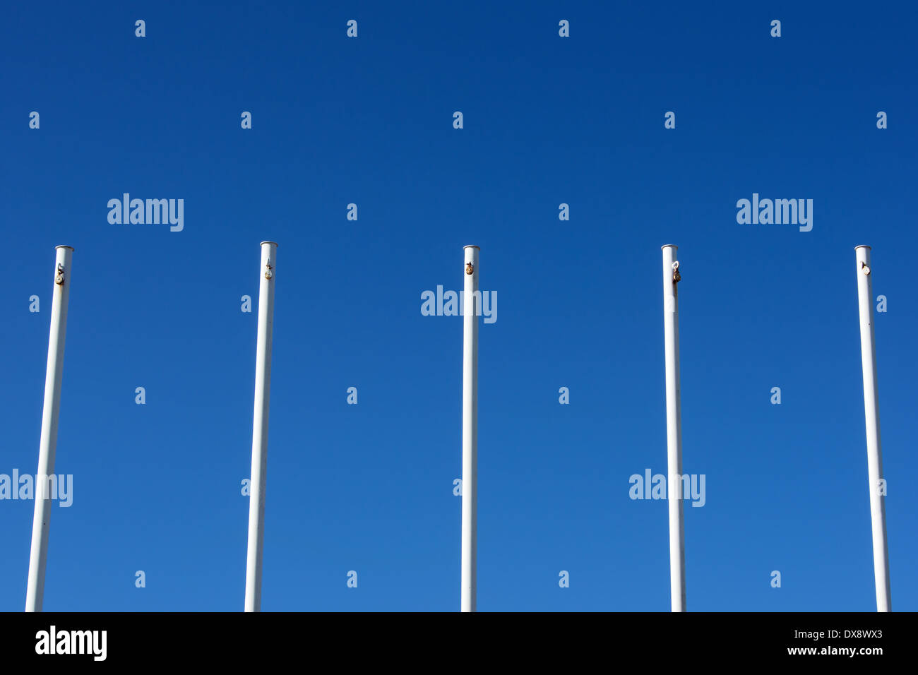 empty white flag poles against blue sky Stock Photo