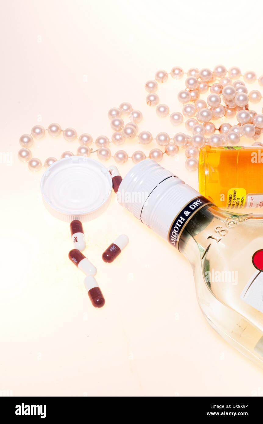 A bottle of rum with pearls and an open bottle of pills Stock Photo Alamy