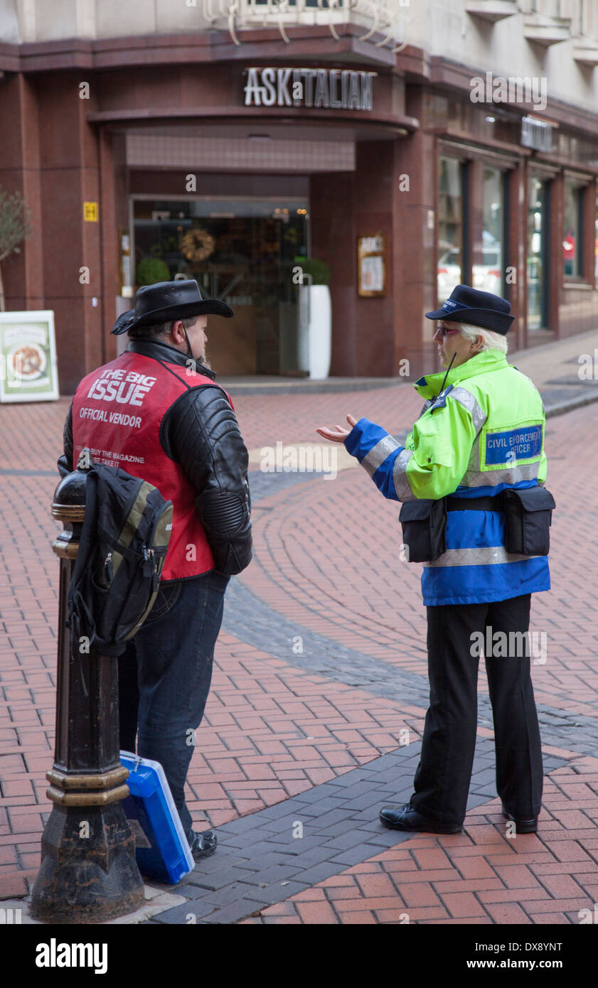 Civil Enforcement Officer talking to a Big Issue seller, Birmingham, England, UK Stock Photo