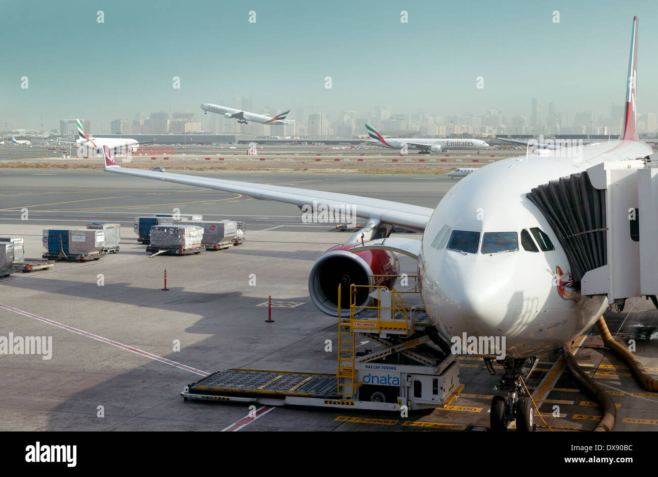 Dubai airport - Virgin Atlantic plane on the ground and Emirates planes taking off; Dubai, UAE United Arab Emirates, Middle East Stock Photo