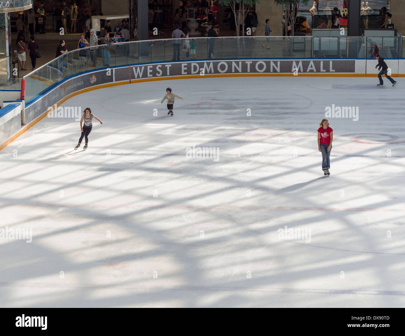 Skating at West Edmonton Mall Ice Palace. Four youths take to the large ice surface inside this huge shopping mall in Edmonton. Stock Photo