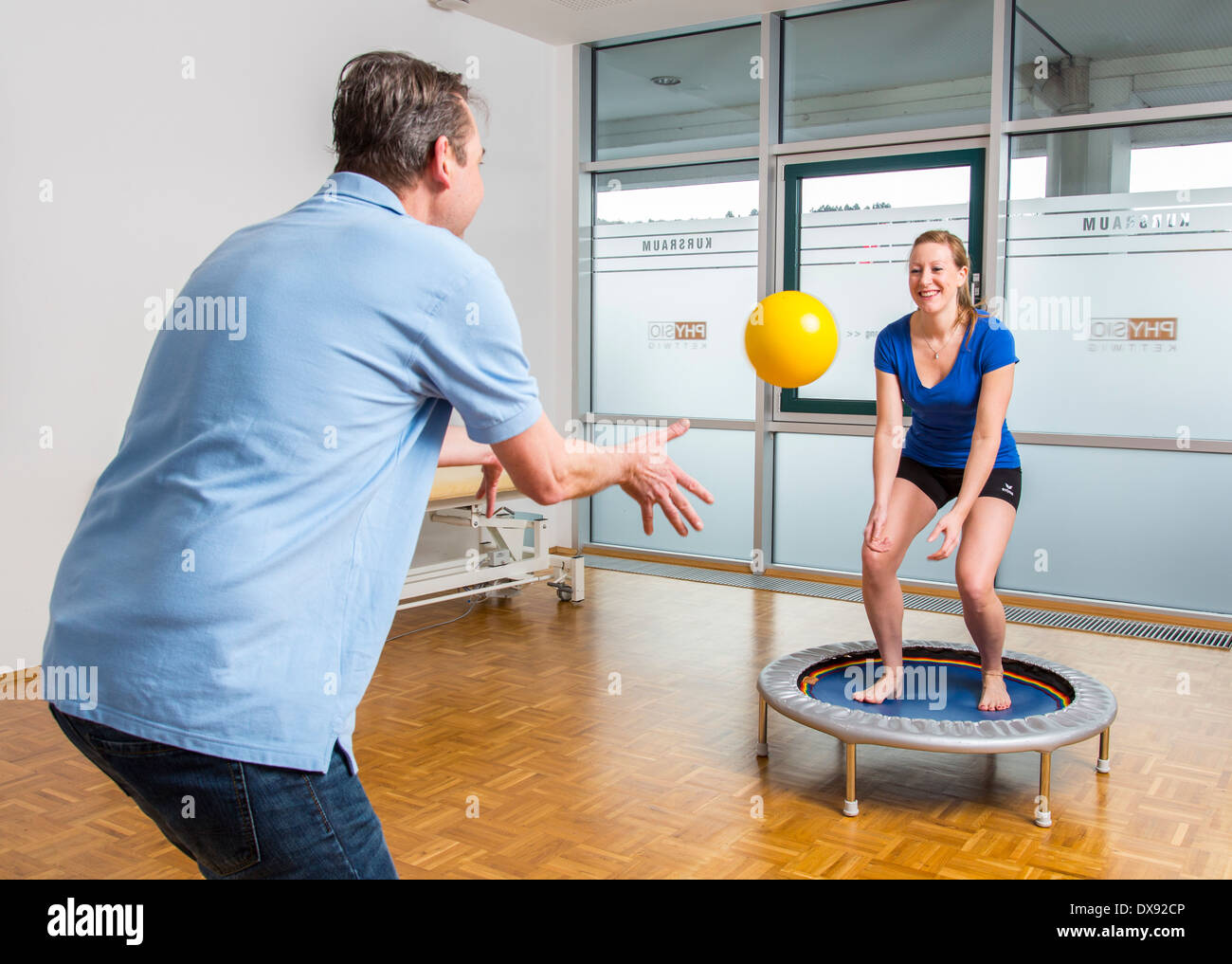 Physiotherapy practice therapist with patient exercise for knee stabilization, specific on a trampoline, sports training, Stock Photo