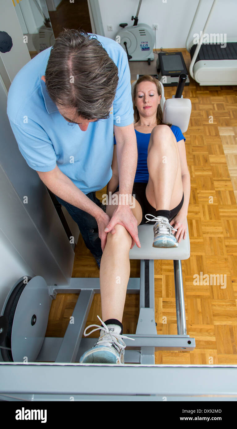 Physiotherapy practice therapist with patient, quadriceps muscle training in the leg press, Stock Photo