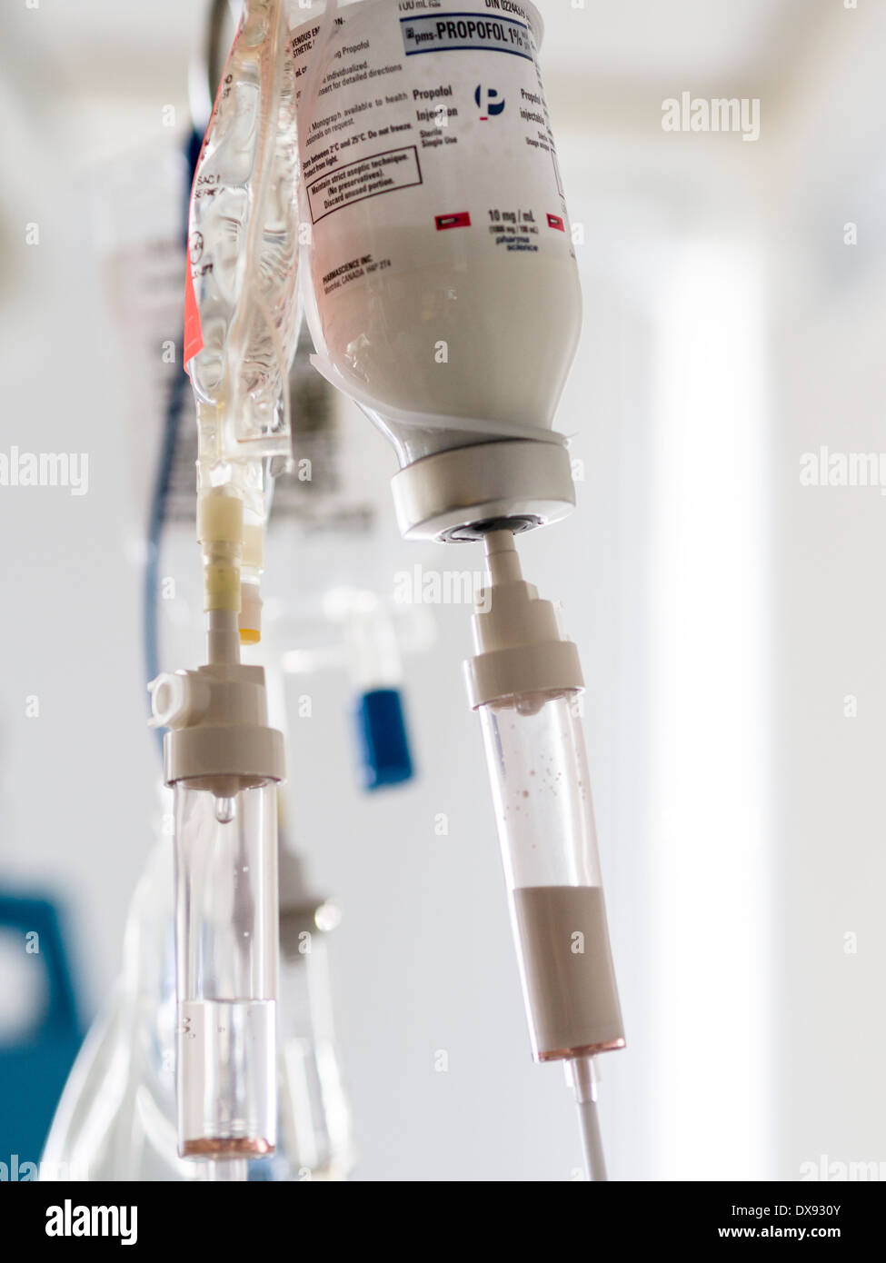Bottle of Propofol Intravenous Drip. A bottle of propofol 1% and another intravenous bag drips in a hospital ICU room. Stock Photo