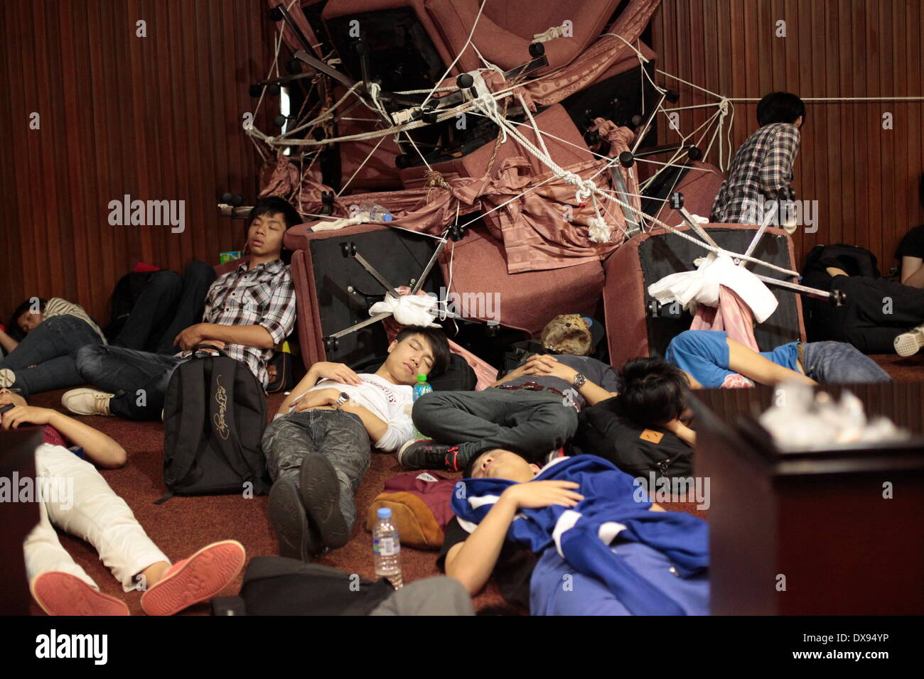 Taipei, Taiwan- March 20, 2014: Protesters slept exhaustedly beside the blocked entrances after several resistances against the storming of police forces on previous day. All entrances were blocked during the standoff to keep the police outside. Thousands of people crowded around Legislative Yuan while hundreds had broken into the building to occupy the legislative chamber since Mar. 18. Credit:  PACIFIC PRESS/Alamy Live News Stock Photo