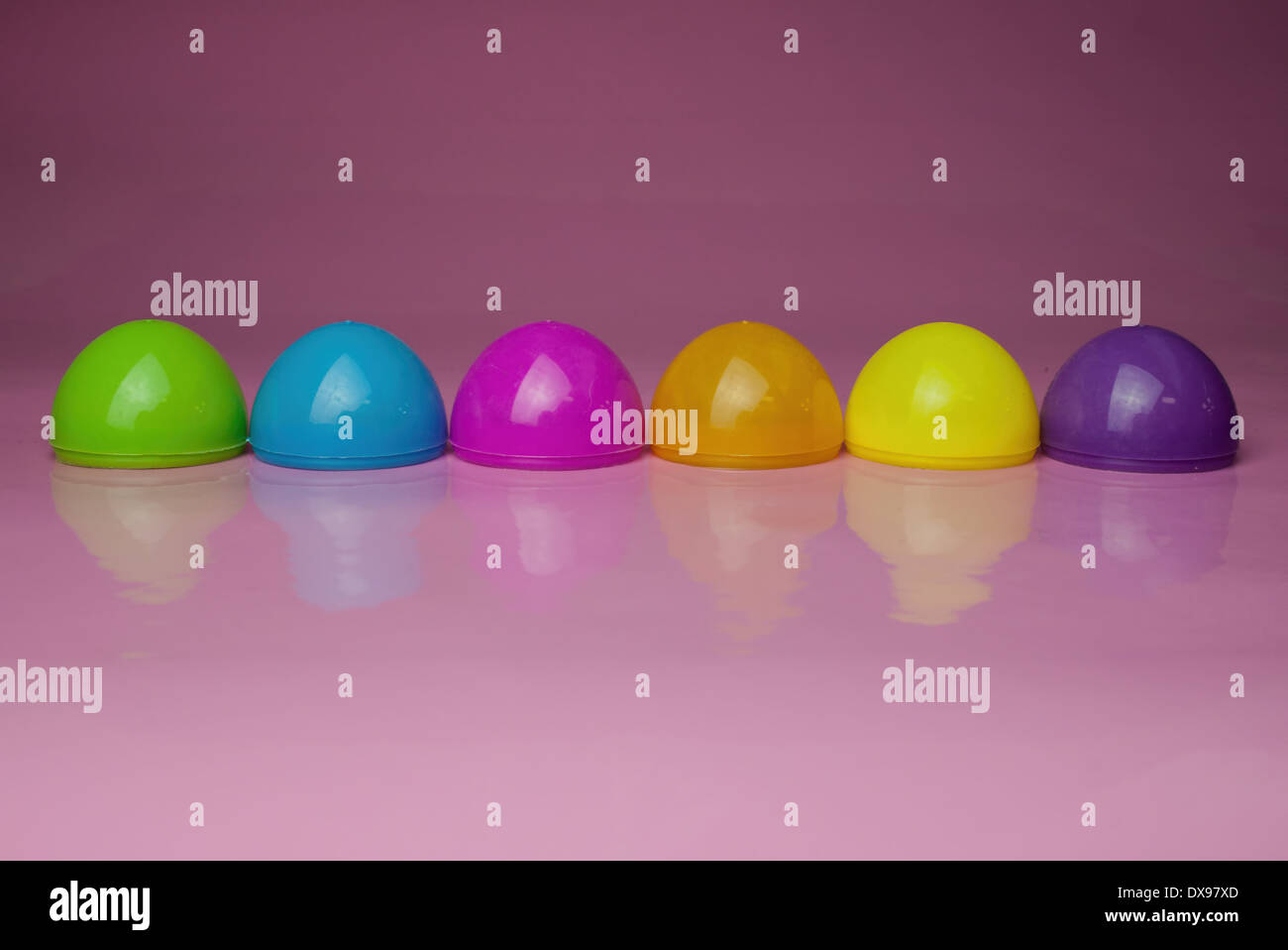 Six Plastic Easter Egg shells on a glossy pink background. cute colorful Easter design Stock Photo