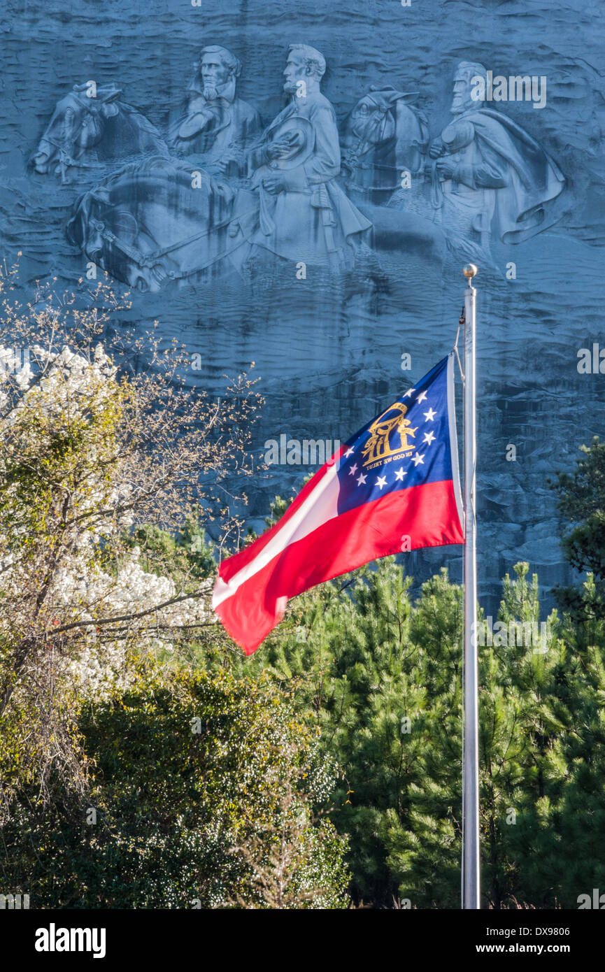 The Georgia state flag waving in the wind beneath the Confederate Memorial carving at Stone Mountain Park in Atlanta, Georgia. Stock Photo
