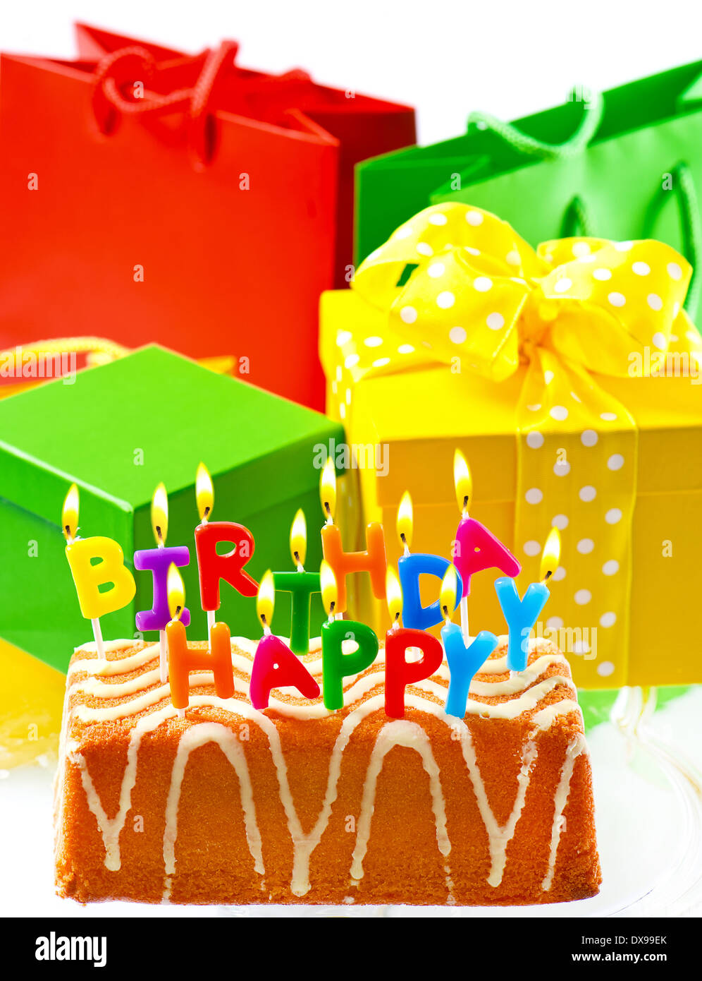 birthday cake with burning candles and gifts. happy birthday to you