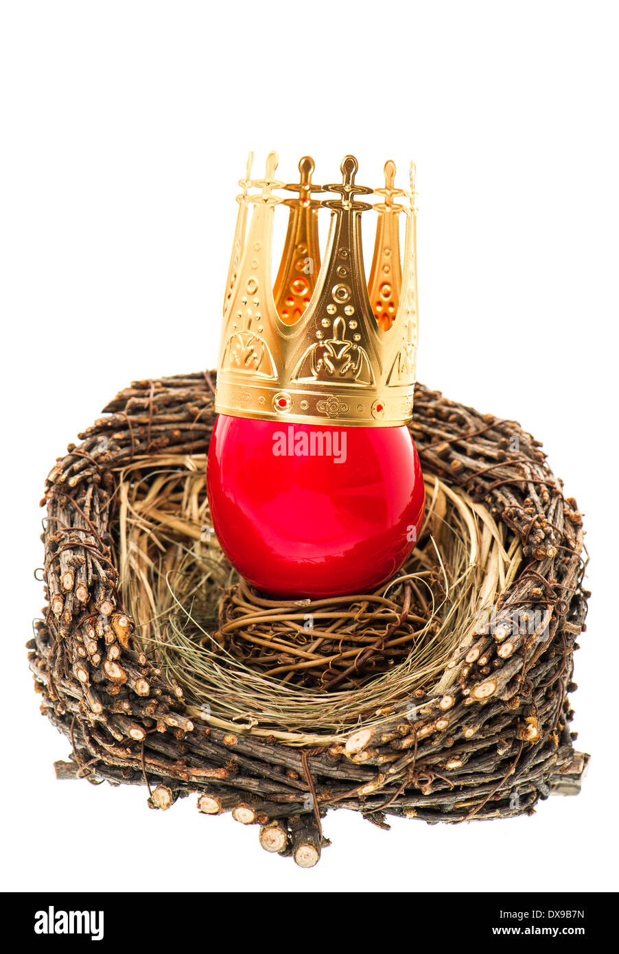 red easter egg with golden crown decoration in wooden nest isolated on white background Stock Photo