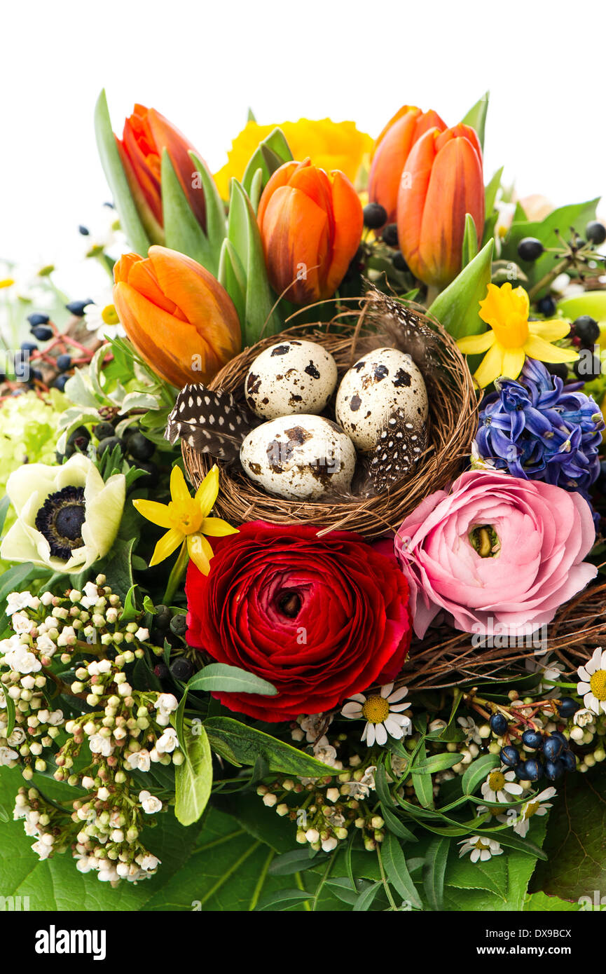 closeup of colorful easter bouquet with eggs decoration over white background. spring flowers tulip, ranunculus, hyacinth, daisy Stock Photo