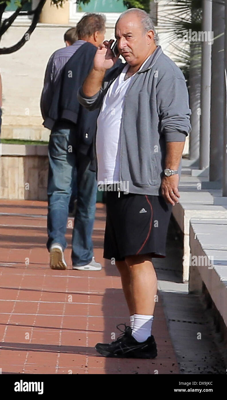 Sir Philip Green chatting on his mobile phone while walking by the