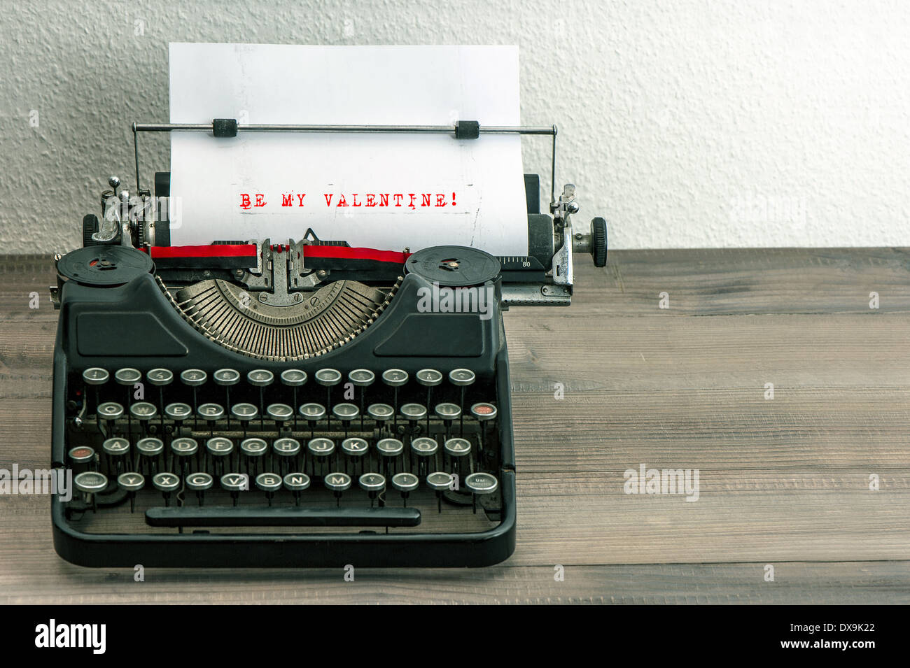 typewriter with white paper page on wooden table. sample text Be My Valentine! Stock Photo