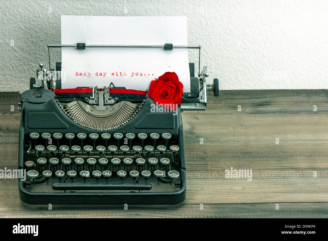 vintage typewriter with love letter and red rose flower. sample text Each day with you... Stock Photo