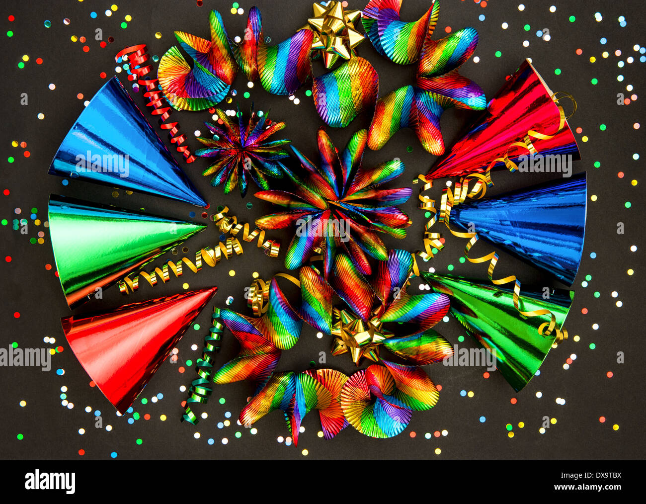 carnival party decoration. colorful garlands, streamer, hats and confetti on black background Stock Photo