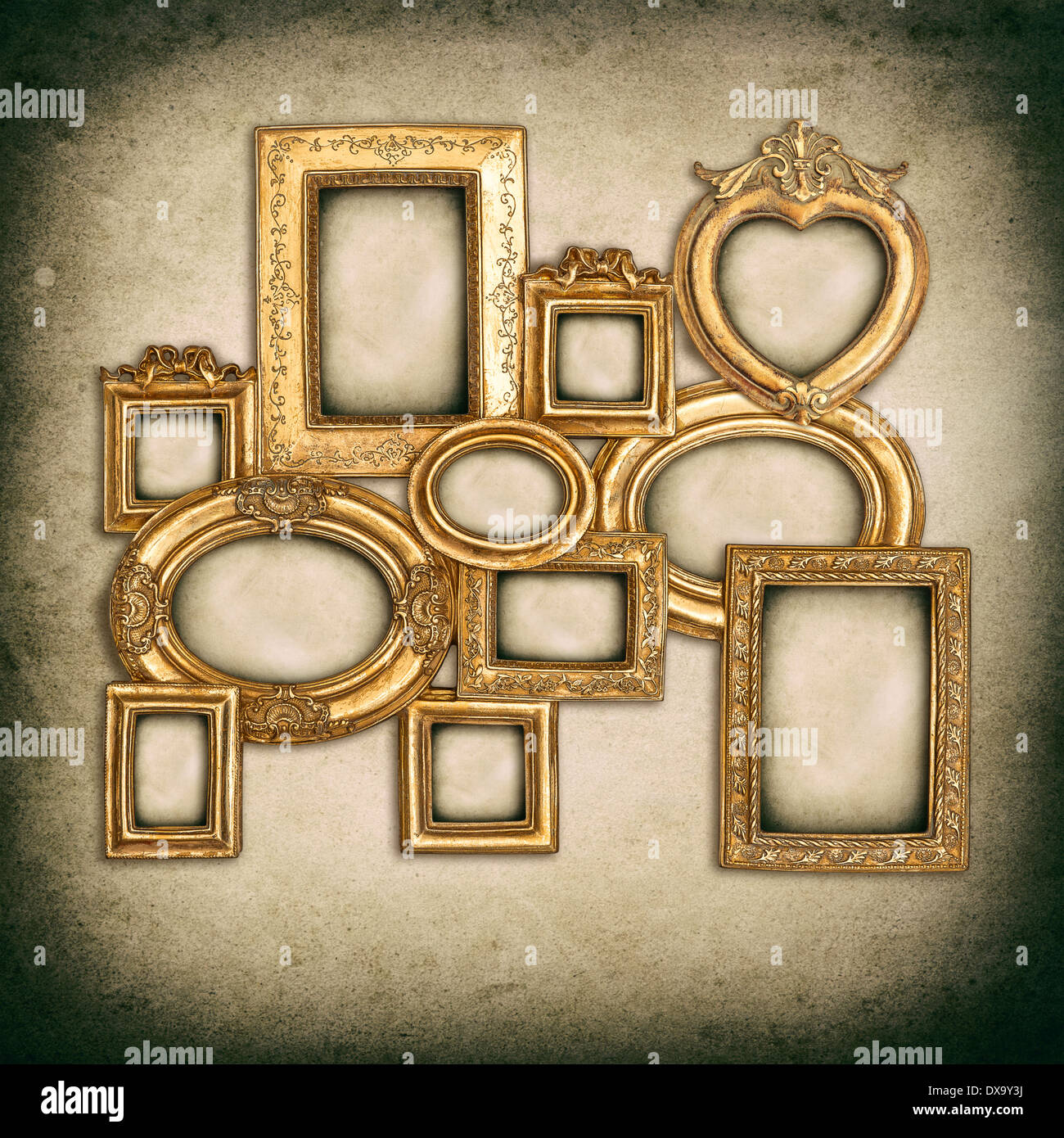 antique golden frames over grungy wall background. empty baroque framework with canvas for photo and picture Stock Photo