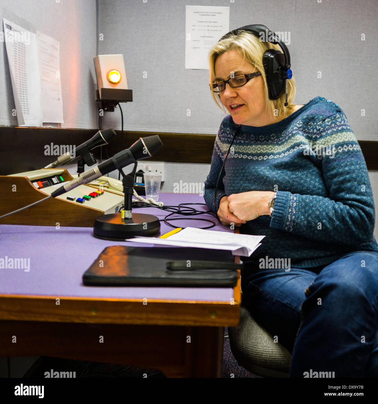 A woman - Elin Haf Gruffydd Jones - contributing to a live welsh BBC Wales radio broadcast from a small regional studio, UK Stock Photo