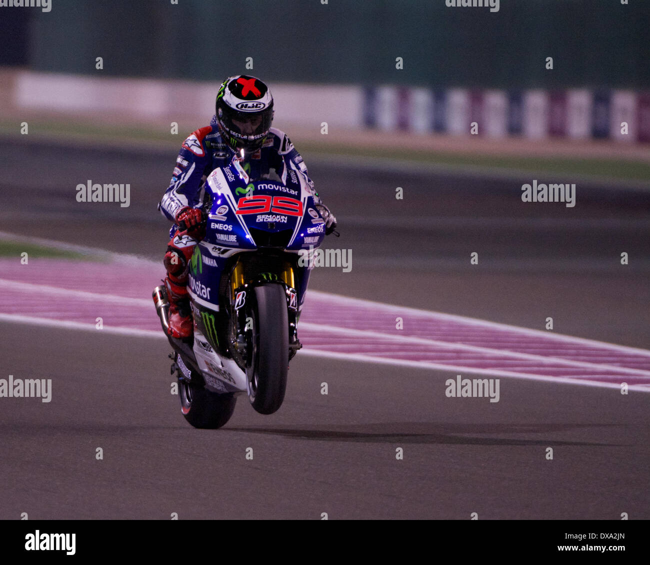 Losail Circuit, Qatar. 20th March 2014.  Jorge Lorenzo the Yamaha Factory Racing rider pulls a wheelie as he leaves the Losail Pit Lane on his Yamaha YZR-M1 for the first free practice session on the 2014 FIM MotoGP World Championship Credit:  Tom Morgan/Alamy Live News Stock Photo