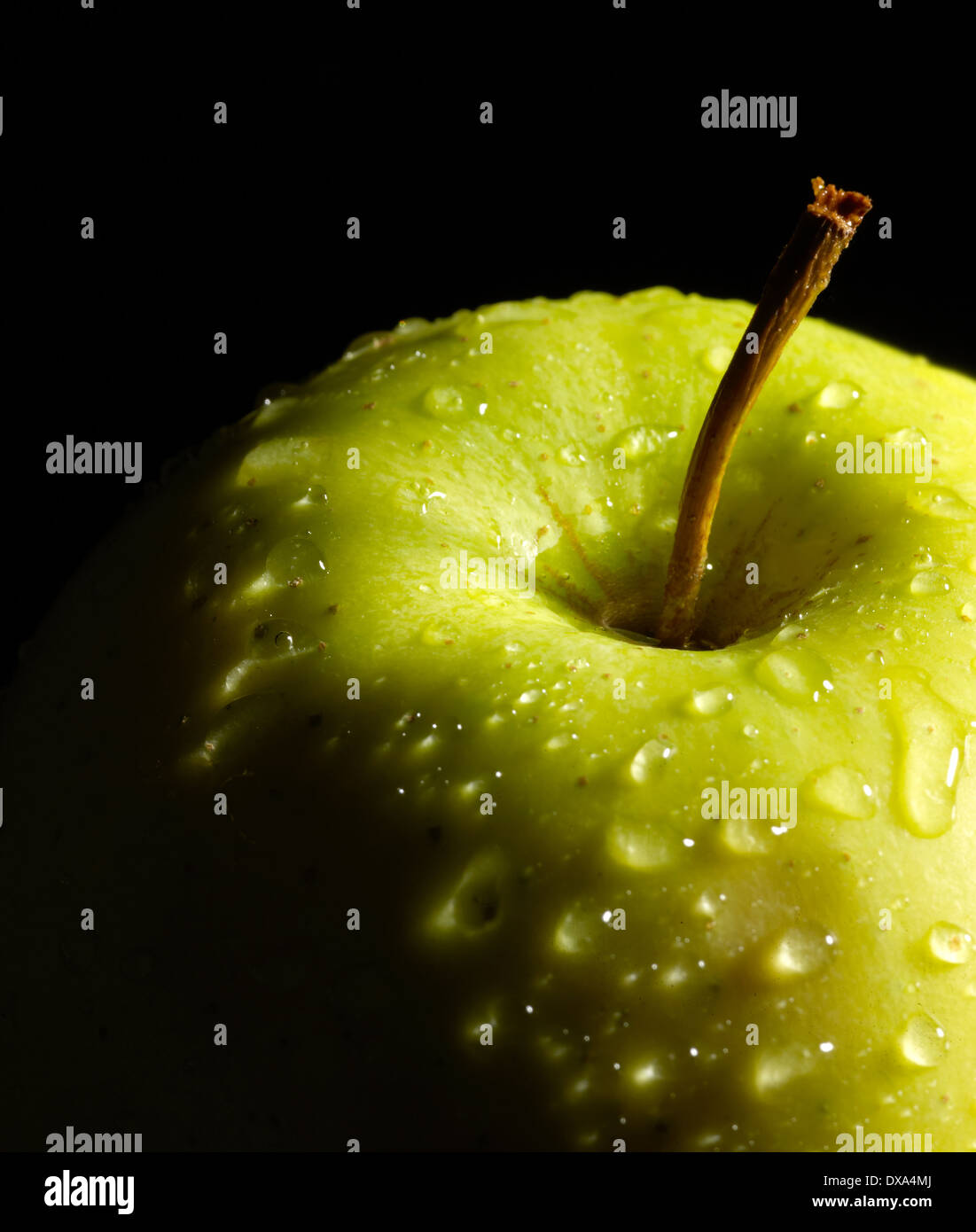 detail of a wet green apple in dark back Stock Photo