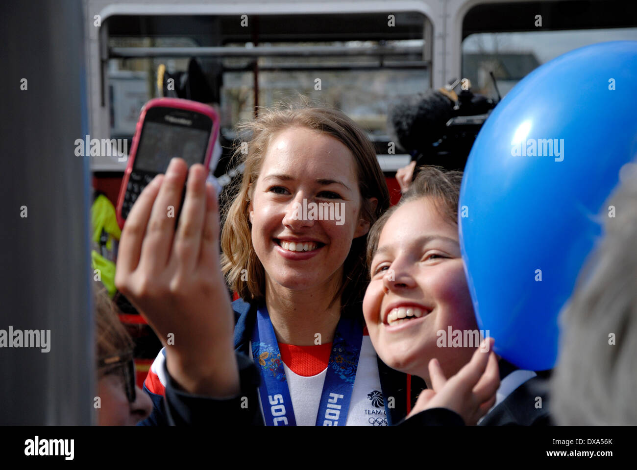 Lizzy Yarnold Victory Parade in Sevenoaks, Kent. 21/03/2014. Winter Olympic gold medal winner Lizzy Yarnold driven from Sevenoaks to her home village of West Kingsdown in Kent in an open-top bus. Posing for a selfie with schoolchildren Stock Photo