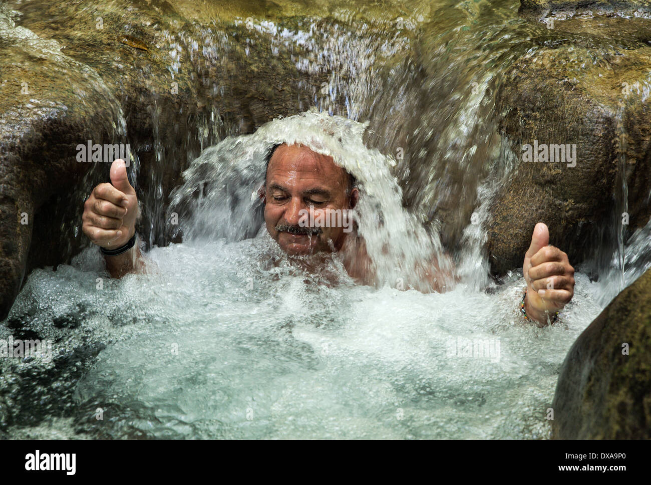 Man enjoys a refreshing water massage at Mayfield Falls, Glenbrook, Jamaica Stock Photo