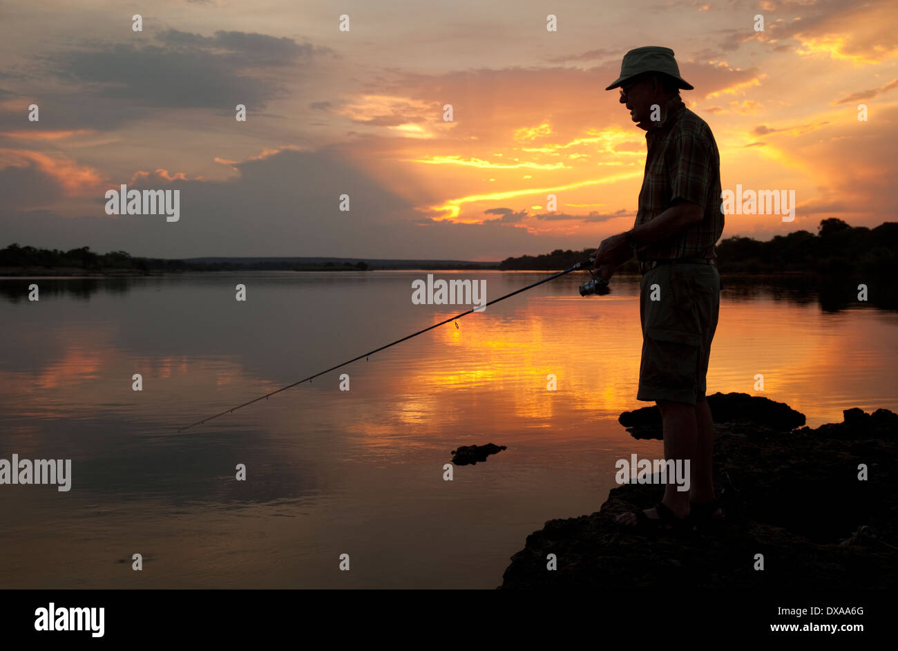 Silhouette of angler fishing in Zambezi River at sunset near Livingstone Zambia Stock Photo