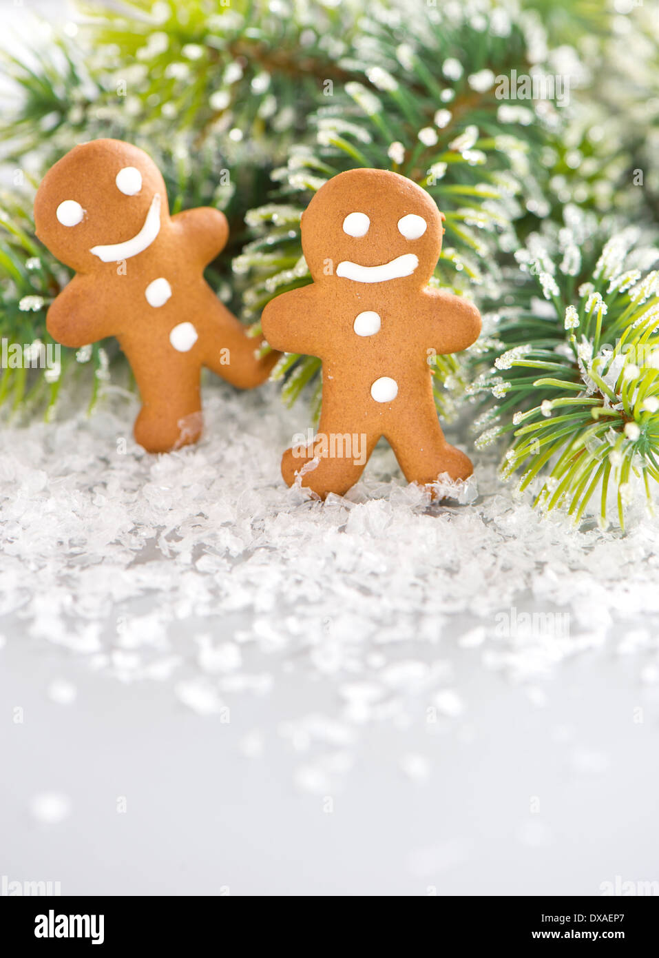 smiling gingerbread man with christmas tree branch in snow Stock Photo