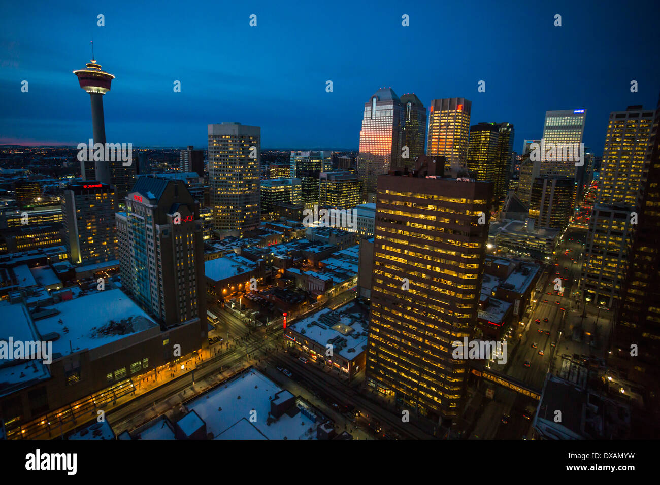 The lights in Calgary's downtown core buildings glow as dawn is reflected in the windows of Bankers Hall. Stock Photo