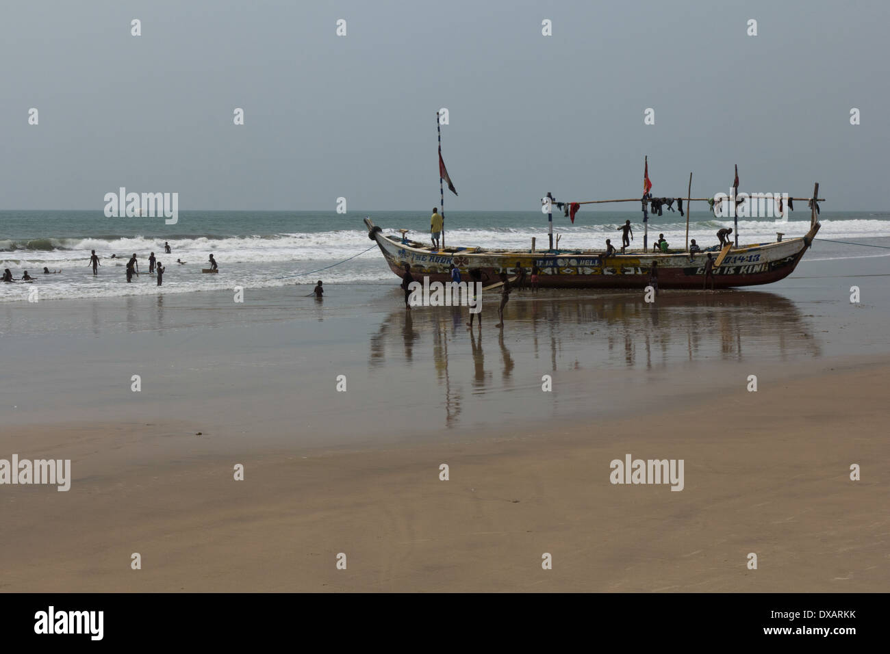 Children playing in fishing boat and in the sea at Kokrobite Beach, Ghana Stock Photo