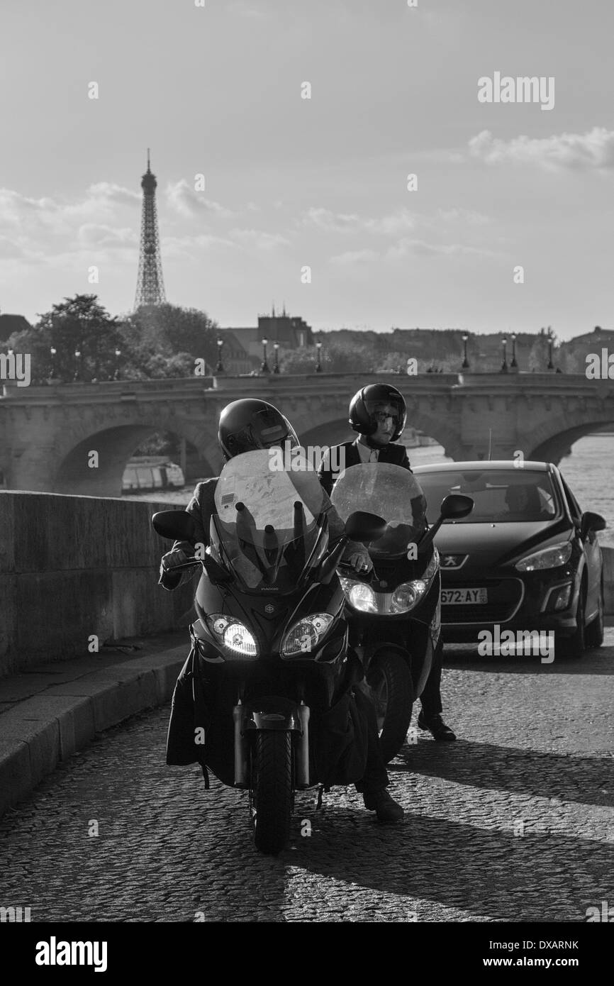 Side street with motorcyclists and Eiffel Tower in the background in Paris Stock Photo