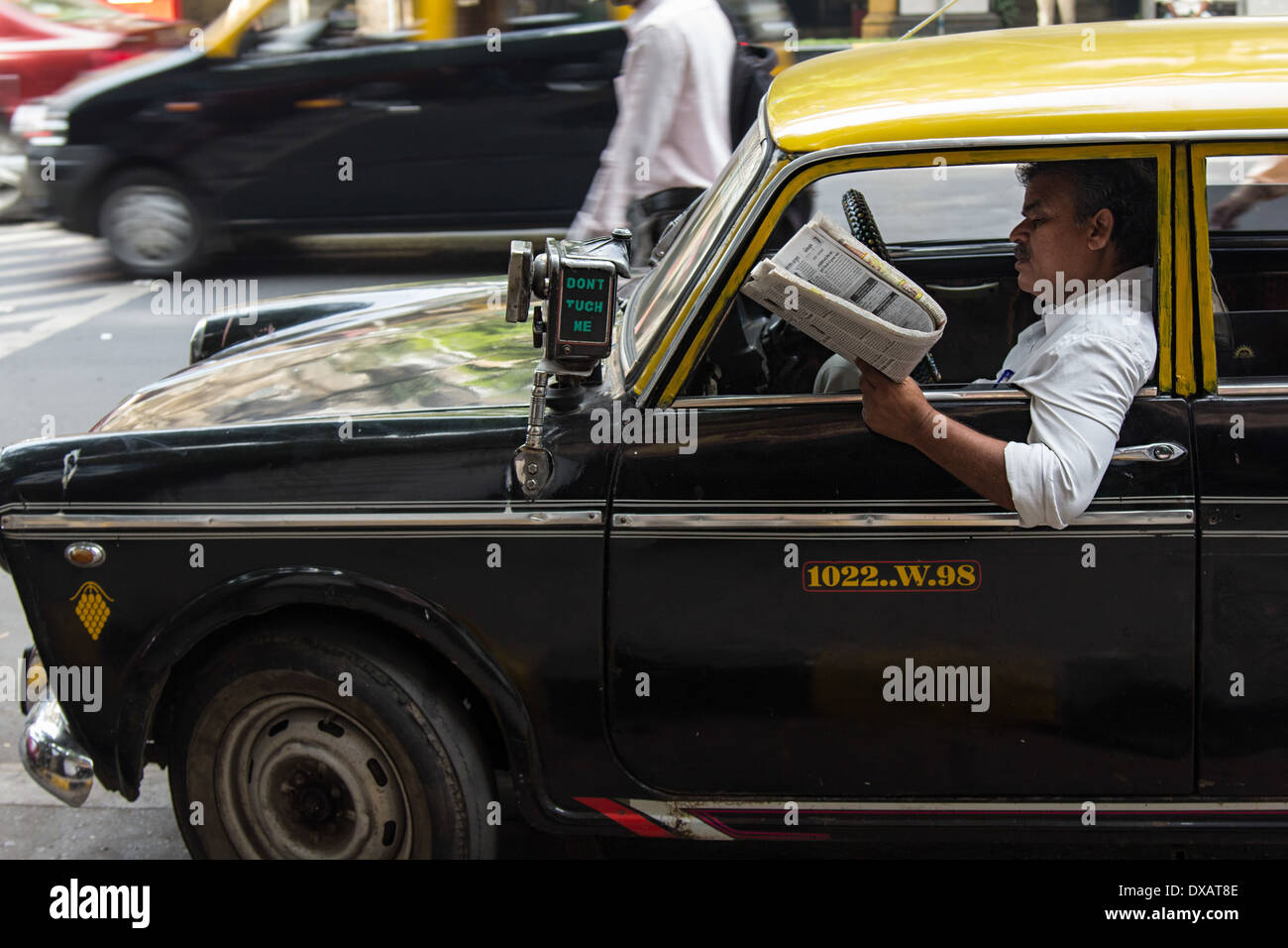 Indian Taxi Driver in old taxi with taxi meter on outside of car in Mumbai, India Stock Photo