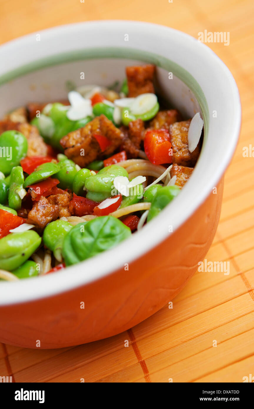 Wholewheat spaghetti with fava beans, red pepper and spicy tofu Stock Photo