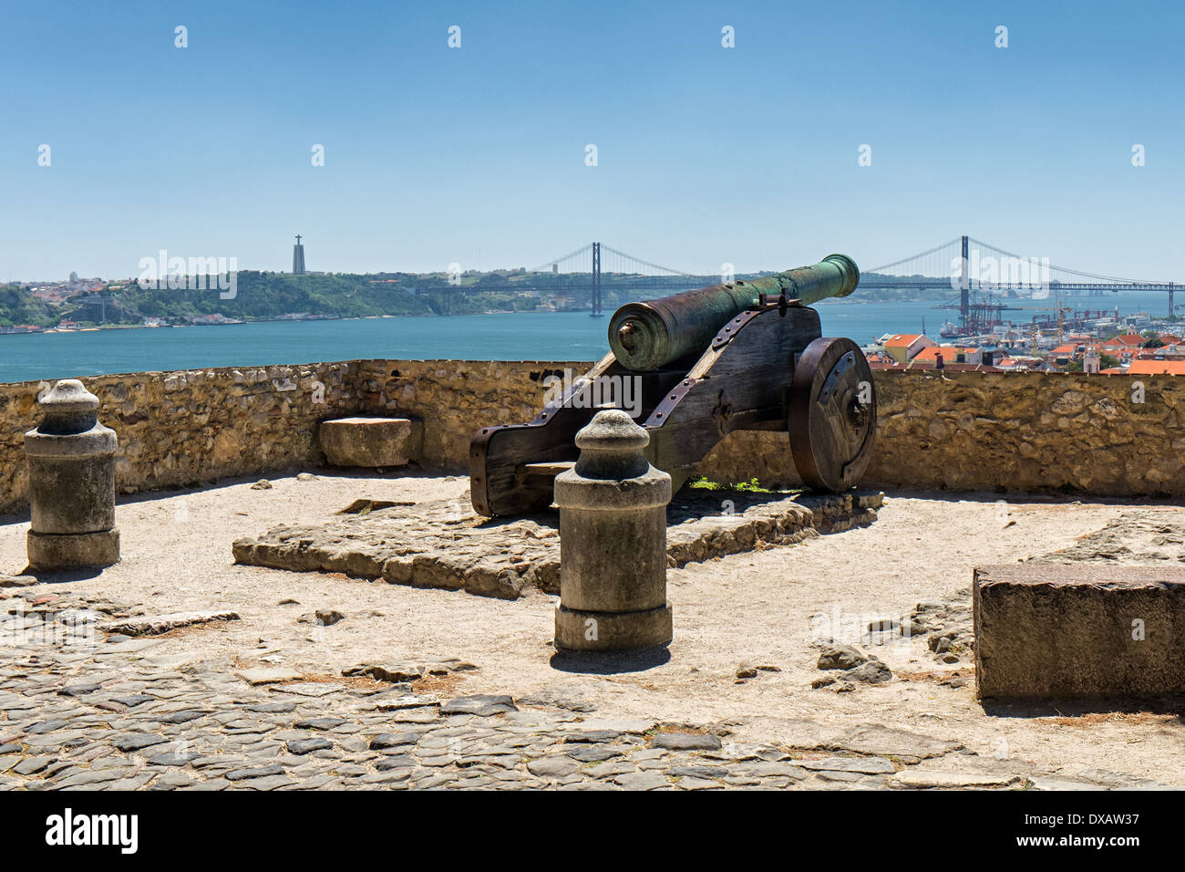 View of a cannon at Castelo de São Jorge pointing towards Cristo Rei statue and Ponte 25 de Abril in Alfama, Lisbon, Portugal Stock Photo