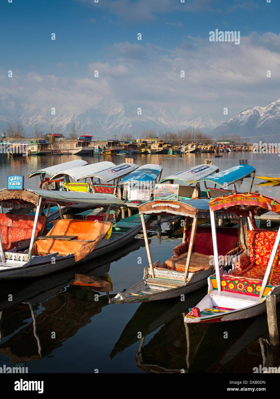 India, Kashmir, Srinagar, Dal Lake, shikaras and houseboats, with view of snow capped Zabarwan mountains Stock Photo