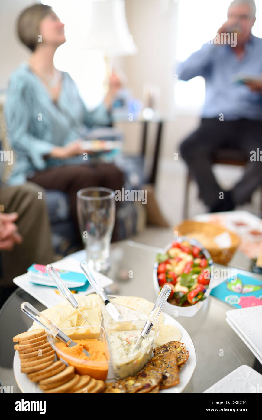 Woman and man talking and enjoying drinks and appetizers in the living room before a dinner party Stock Photo