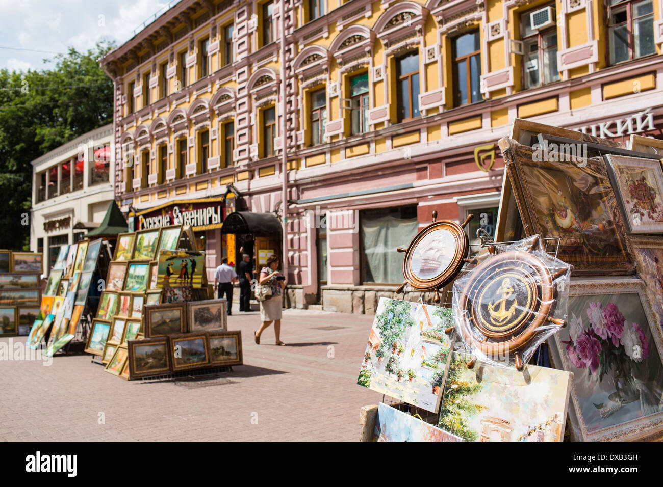 Tourists pass artworks for sale in Arbat street, Moscow, Russia Stock Photo