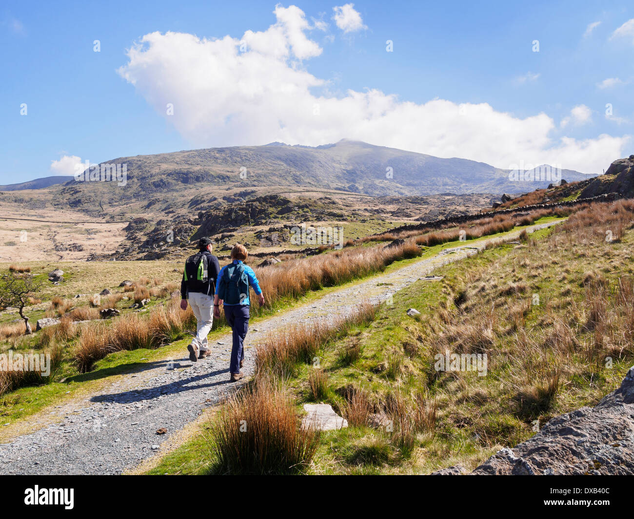 Walkers walking on Rhyd Ddu path up to Mount Snowdon with a view to peak in distance in Snowdonia National Park. Gwynedd North Wales UK Stock Photo