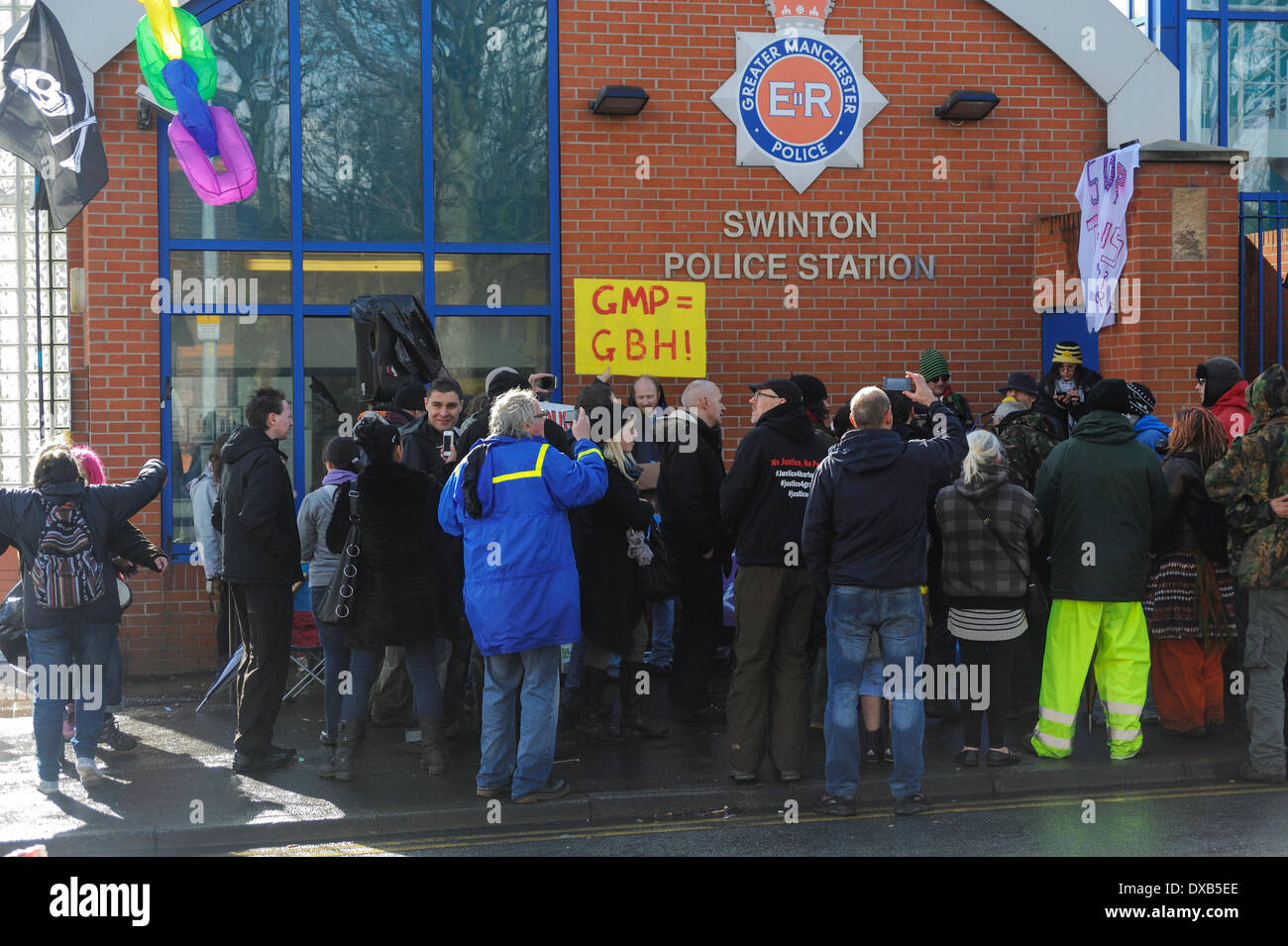 Swinton, Salford, Manchester, UK . 22nd March 2014. Anti-fracking campaigners protest outside Swinton police station, Salford, Manchester. Anti-fracking protesters gather in front of Swinton police station, one holding up a sign suggesting that the Greater Manchester Police are guilty of Grievious Bodily Harm. Credit:  Dave Ellison/Alamy Live News Stock Photo