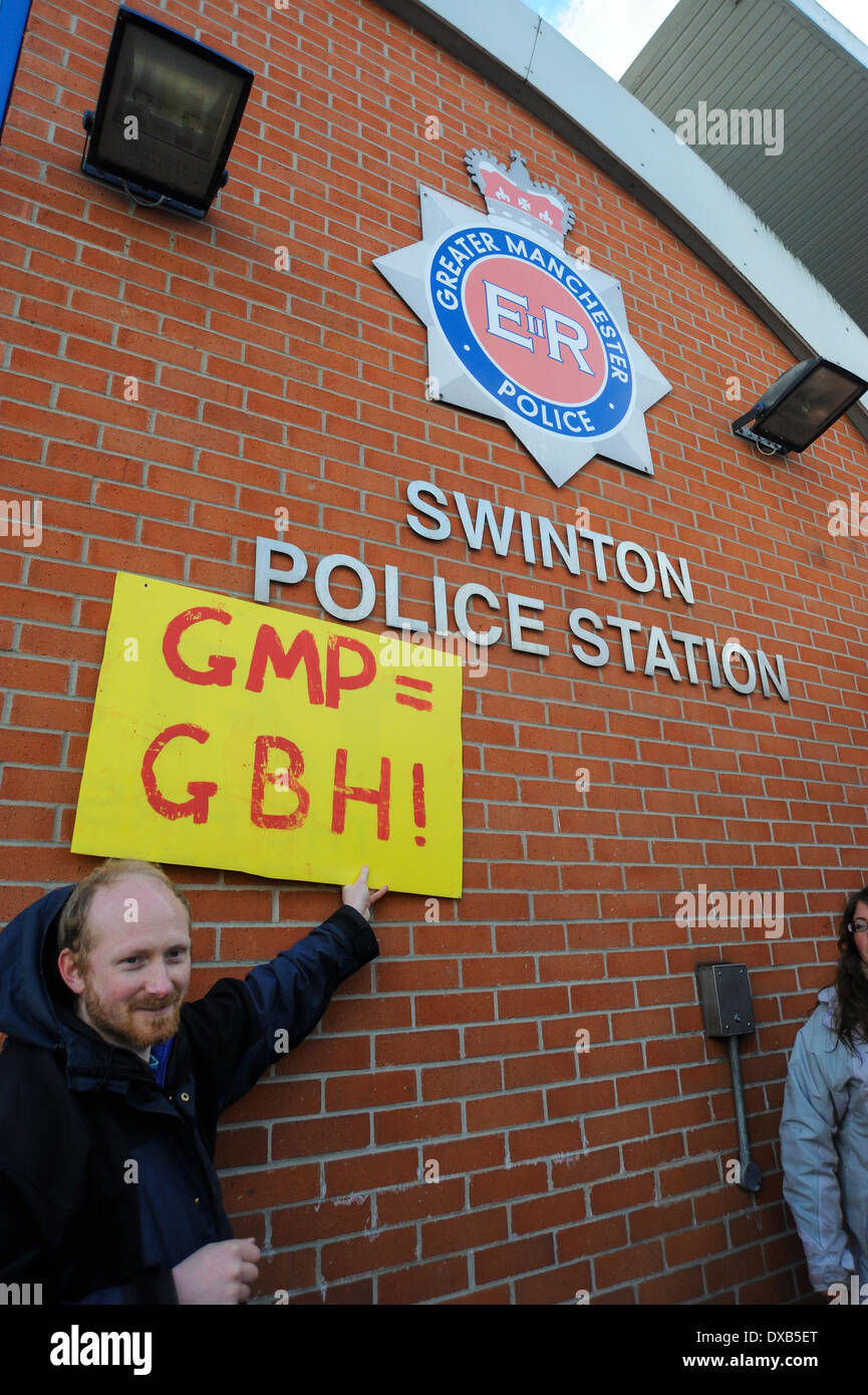 Swinton, Salford, Manchester, UK . 22nd March 2014. Anti-fracking campaigners protest outside Swinton police station, Salford, Manchester. Greater Manchester Police equals Grievious Bodily Harm sign held below the police station sign. Credit:  Dave Ellison/Alamy Live News Stock Photo