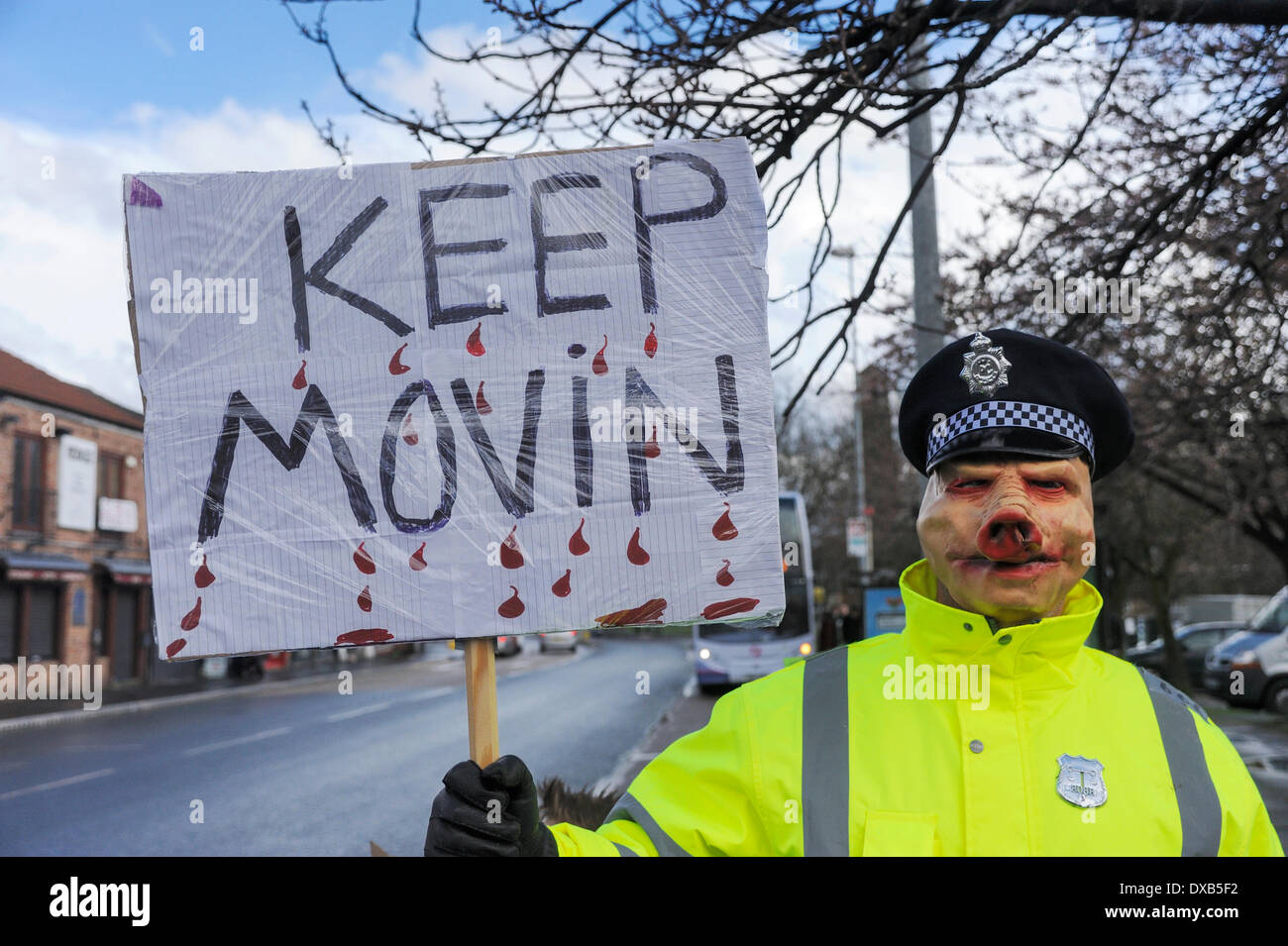 Swinton, Salford, Manchester, UK . 22nd March 2014. Anti-fracking campaigners protest outside Swinton police station, Salford, Manchester. Protester dressed as a policeman wearing a pig mask holding a sign 'Move on'. Credit:  Dave Ellison/Alamy Live News Stock Photo